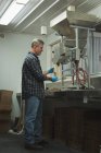 Man refining grain in machine at factory — Stock Photo