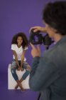 Professional Photographer taking picture of model in studio — Stock Photo