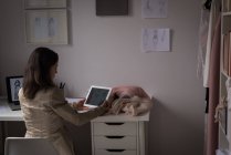 Modedesignerin mit digitalem Tablet am Schreibtisch im Designstudio. — Stockfoto