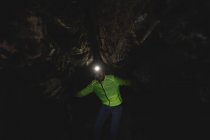 Caminhante explorando a caverna escura — Fotografia de Stock