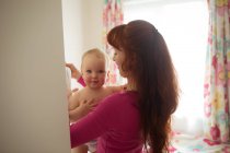 Mather holding her baby girl at home — Stock Photo