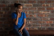 Счастливая девушка разговаривает по мобильному телефону в офисе . — стоковое фото