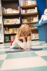 Mädchen liest ein Buch im Buchladen — Stockfoto