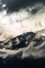 Mountain top surrounded with clouds at evening — Stock Photo