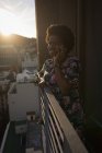 Femme parlant sur téléphone portable dans le balcon à la maison . — Photo de stock