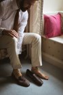 Groom wearing his shoes at home — Stock Photo