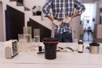 Обложка объектива камеры с химикатами на столе в фотостудии — стоковое фото