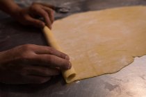 Bäcker faltet einen ausgerollten Mehlteig für die Herstellung von Nudeln — Stockfoto