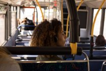 Вид збоку на жіночу комп'ютерну прослуховування музики під час подорожі в сучасному автобусі — стокове фото