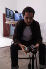 Чоловік-фотограф тримає рулонну плівку і камеру в фотостудії — стокове фото