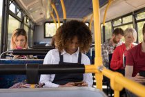 Молода жінка використовує мобільний телефон під час подорожі в сучасному автобусі — стокове фото