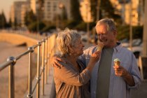 Glückliches Seniorenpaar beim Eis essen an der Promenade — Stockfoto