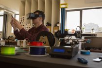Mecánico con auriculares de realidad virtual en taller - foto de stock