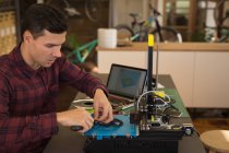 Aufmerksamer Mechaniker nimmt Kettenblatt aus Werkzeugmaschine in Werkstatt — Stockfoto