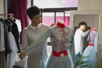 Fashion designer taking measurement of mannequin in fashion studio — Stock Photo