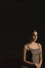 Продумана балерина дивиться на чорний фон — стокове фото