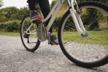 Низкая часть девушки езда на велосипеде по улице — стоковое фото