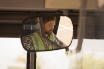Reflection of smart driver in mirror driving bus — Stock Photo