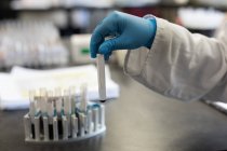 Лабораторний технік, що аналізує хімічний розчин у банку крові — стокове фото