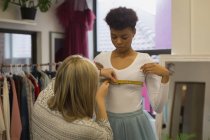 Модный дизайнер проводит измерения клиента в студии моды — стоковое фото