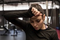 Junge Frau wischt sich nach Training im Fitnessstudio den Schweiß ab — Stockfoto