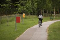 Visão traseira da menina andando de bicicleta na rua — Fotografia de Stock