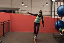 Junge Frau macht Übung mit Gummiband in Fitnessstudio — Stockfoto