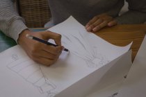 Close-up of fashion designer drawing sketch in fashion studio — Stock Photo