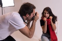 Fotógrafo masculino clicando fotos de modelo no estúdio de fotografia — Fotografia de Stock