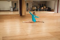 Veduta posteriore della ballerina che pratica danza classica in studio — Foto stock