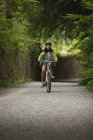 Young girl riding bicycle on street — Stock Photo