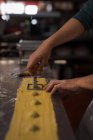 Крупный план мужского пекаря, готовящего макароны в пекарне — стоковое фото