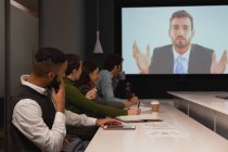 Pessoas de negócios interagindo através de videochamada em conferência no escritório — Fotografia de Stock