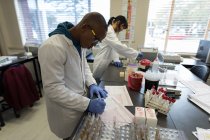 Técnico de laboratório verificando faturas no banco de sangue — Fotografia de Stock