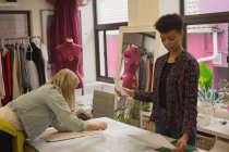 Stilista di moda che lavora sul tavolo nello studio di moda — Foto stock
