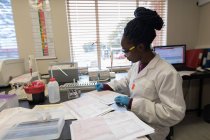 Technicien de laboratoire vérifiant les factures dans la banque de sang — Photo de stock