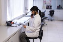 Tecnico di laboratorio che parla al telefono in banca del sangue — Foto stock
