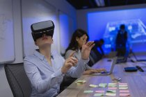 Бізнес-леді, використовуючи гарнітуру віртуальної реальності в конференц-залі в офісі — стокове фото