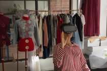 Diseñador de moda usando auriculares de realidad virtual en estudio de moda - foto de stock