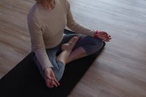 Femme âgée effectuant du yoga dans le centre de yoga — Photo de stock