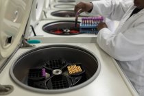 Technicien de laboratoire plaçant le tube à essai dans la machine à la banque de sang — Photo de stock