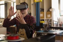 Человек с помощью гарнитуры виртуальной реальности в мастерской — стоковое фото