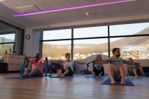Trainerin und Gruppe älterer Frauen, die Yoga im Yogazentrum durchführen — Stockfoto