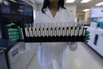 Лабораторний технік тримає пробірки в банку крові — стокове фото