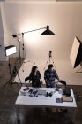 Photographe masculin et féminin regardant des photos en studio photo — Photo de stock