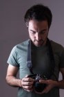 Male photographer standing with digital camera in photo studio — Stock Photo