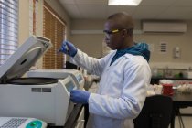 Laboratory technician using refrigerated centrifuge machine in blood bank — Stock Photo