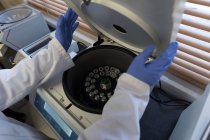 Лабораторний технік, що використовує холодильну центрифужну машину в банку крові — стокове фото