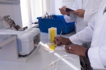Seção intermediária do técnico de laboratório escrevendo em uma etiqueta no banco de sangue — Fotografia de Stock