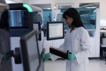 Лабораторный техник держит пробирки в банке крови — стоковое фото